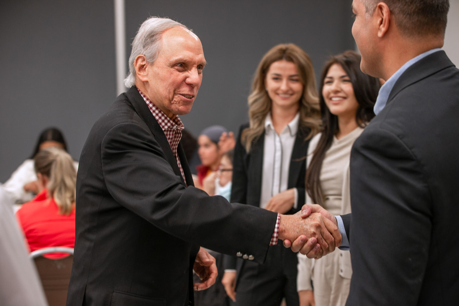 Martin D. Sass ’63, Chairman and CEO of M.D. Sass, one of the nation’s leading independent registered investment management firms, is greeted by a student at the M.D. Sass Investment Institute dinner last November. The institute, established in 2015 as an experiential learning initiative in the Koppelman School of Business, engages Brooklyn College students in research on an active investment fund.